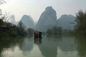 Un barco en un río tranquilo con montañas al fondo.