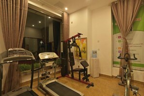A fitness room with a treadmill, exercise bike, and weight machine.