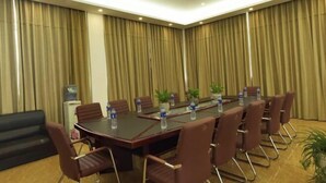A conference room with a long table, brown chairs, and water bottles. - GreenTree (Shuyang Development Zone Yingbin Avenue) (Shuyang)