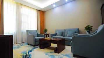 A modern living room with a sofa, two armchairs, a coffee table, and a decorative rug.