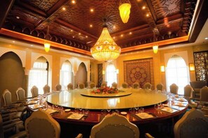 A conference room with a large oval table, multiple chairs, and a chandelier.