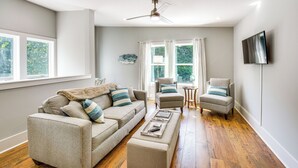 A living room with a sofa, armchair, ottoman, and a ceiling fan. - Dock Access & Patio! Waterfront Apt in Hartwell (Hartwell)