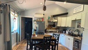 A kitchen with white cabinets, a wooden dining table, and a patterned rug. - Idyllic Idaho Getaway: Your Spirit Lake Sanctuary (Spirit Lake)