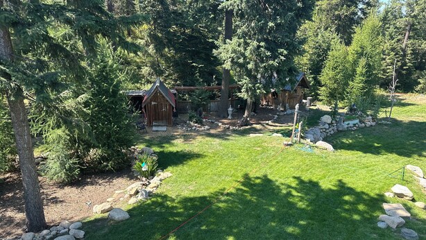A wooden cabin surrounded by a well-maintained lawn and trees. - Idyllic Idaho Getaway: Your Spirit Lake Sanctuary (Spirit Lake)
