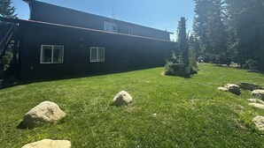 A modern two-story house with a flat roof, large windows, and a well-maintained lawn with rocks. - Idyllic Idaho Getaway: Your Spirit Lake Sanctuary (Spirit Lake)