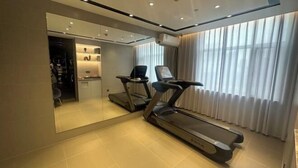 A modern hotel room with a treadmill, a large mirror, and a view of the city through large windows. - Homeinn · neo (Shijiazhuang Xinbai Square Wanli Temple Pedestrian Street) (Shijiazhuang)