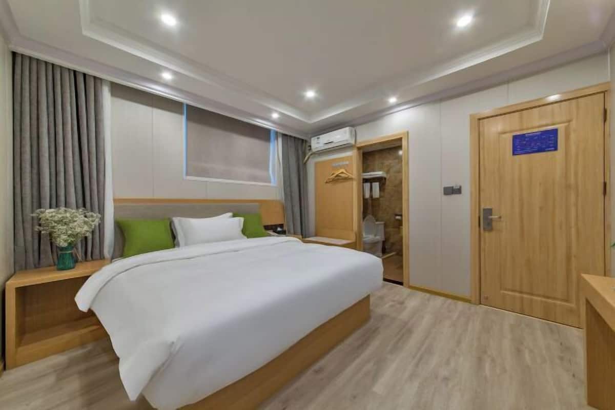 Ein Hotelzimmer mit Bett, Nachttisch und Kleiderschrank.