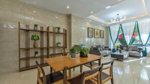 A modern living room with a wooden dining table, comfortable seating, and a large window with curtains. - Boffin Holiday Inn (Lijiang)