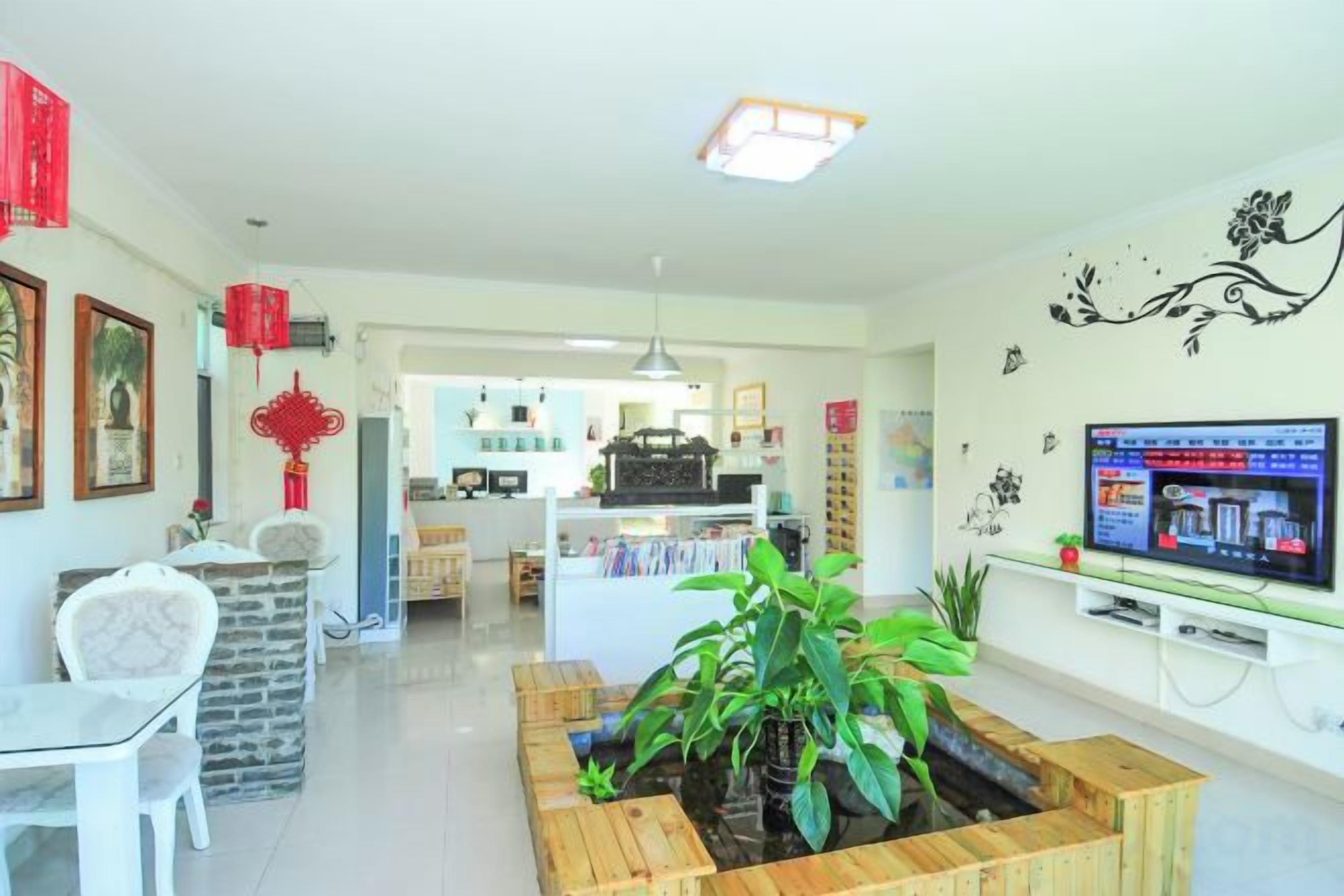 Una sala de estar con televisor, un comedor con mesa y sillas, y una cocina al fondo.