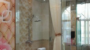 Un baño moderno con cabina de ducha de vidrio, inodoro y lavamanos.