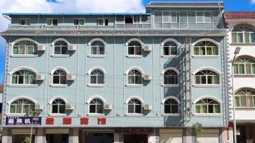 A multi-story building with a flat facade, multiple windows, and a visible entrance with signage.