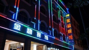 Un hotel con letreros de neón en varios colores, incluyendo azul, rojo y verde.