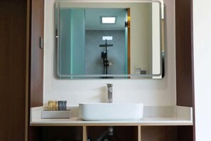 A bathroom with a white sink, a mirror, and a shower. - Lugu Lake Yongzhen Hotel (Ninglang)