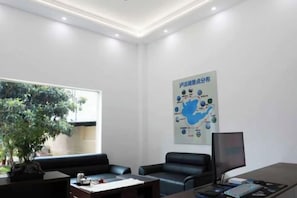 A modern office with a desk, two chairs, a computer, and a large window. - Lugu Lake Yongzhen Hotel (Ninglang)