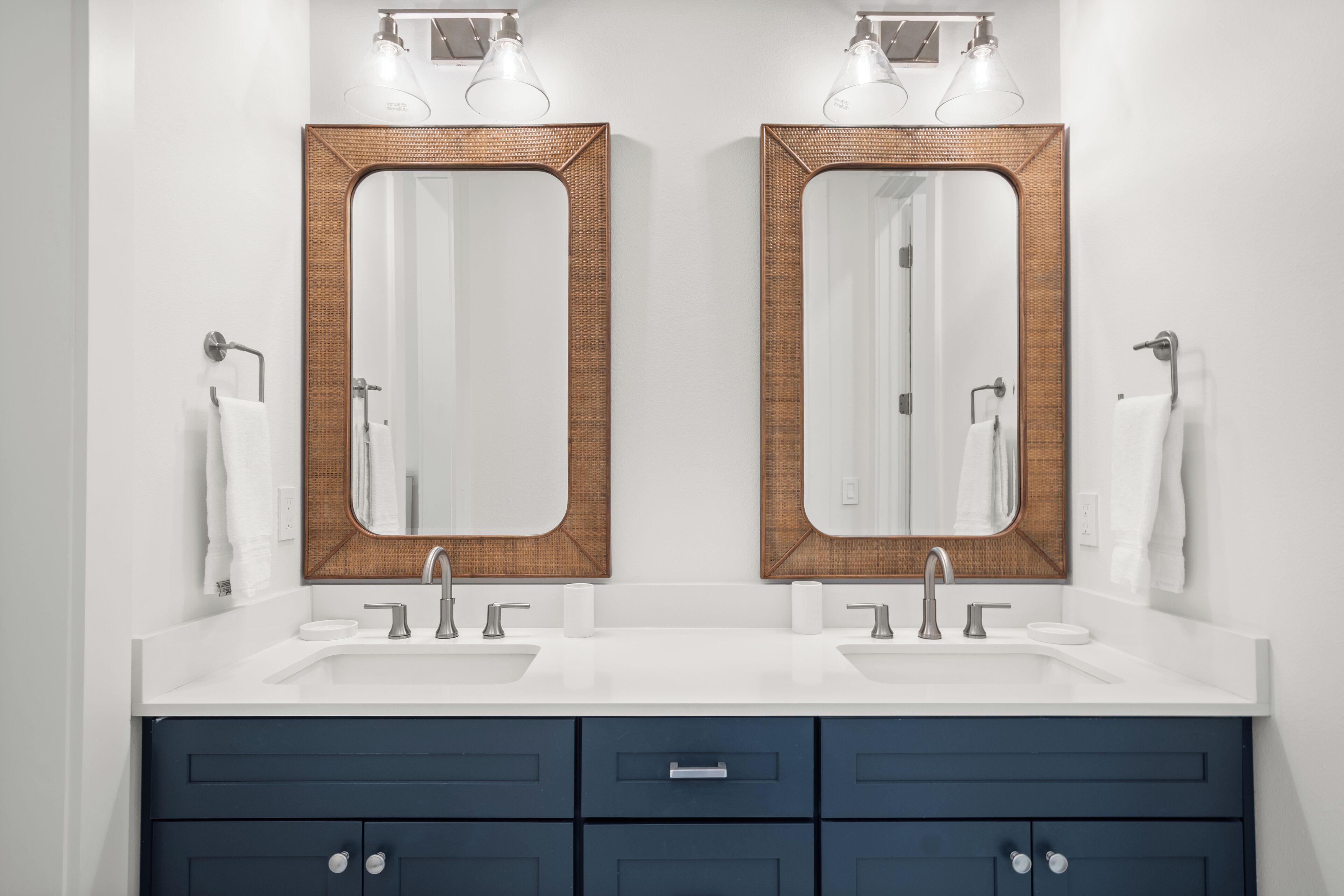 A bathroom with two sinks, a mirror, and a towel rack.