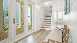 Ein modernes Interieur mit Treppe, Holzboden und Essbereich mit Tisch und Stühlen.