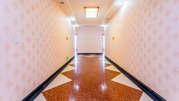 A hallway with patterned wallpaper, a polished floor, and a ceiling light fixture. - Jinyuan Hotel (Emeishan City)