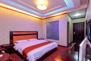 A hotel room with a large bed, a television, and a window. - Jinyuan Hotel (Emeishan City)