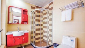 A bathroom with a glass shower enclosure, a red vanity, and a white toilet. - Jinyuan Hotel (Emeishan City)