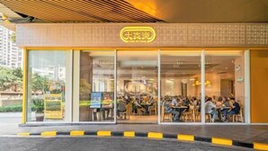 A cafe with a large glass window and a sign above the entrance. - Angda Pazhou Apartment (Guangzhou Pazhou International Exhibition Center) (Guangzhou)