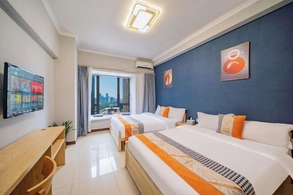 A hotel room with two beds, a TV, a desk, and a window with a city view. - Angda Pazhou Apartment (Guangzhou Pazhou International Exhibition Center) (Guangzhou)