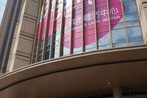 A building facade with large windows and a curved structure. - Angda Pazhou Apartment (Guangzhou Pazhou International Exhibition Center) (Guangzhou)