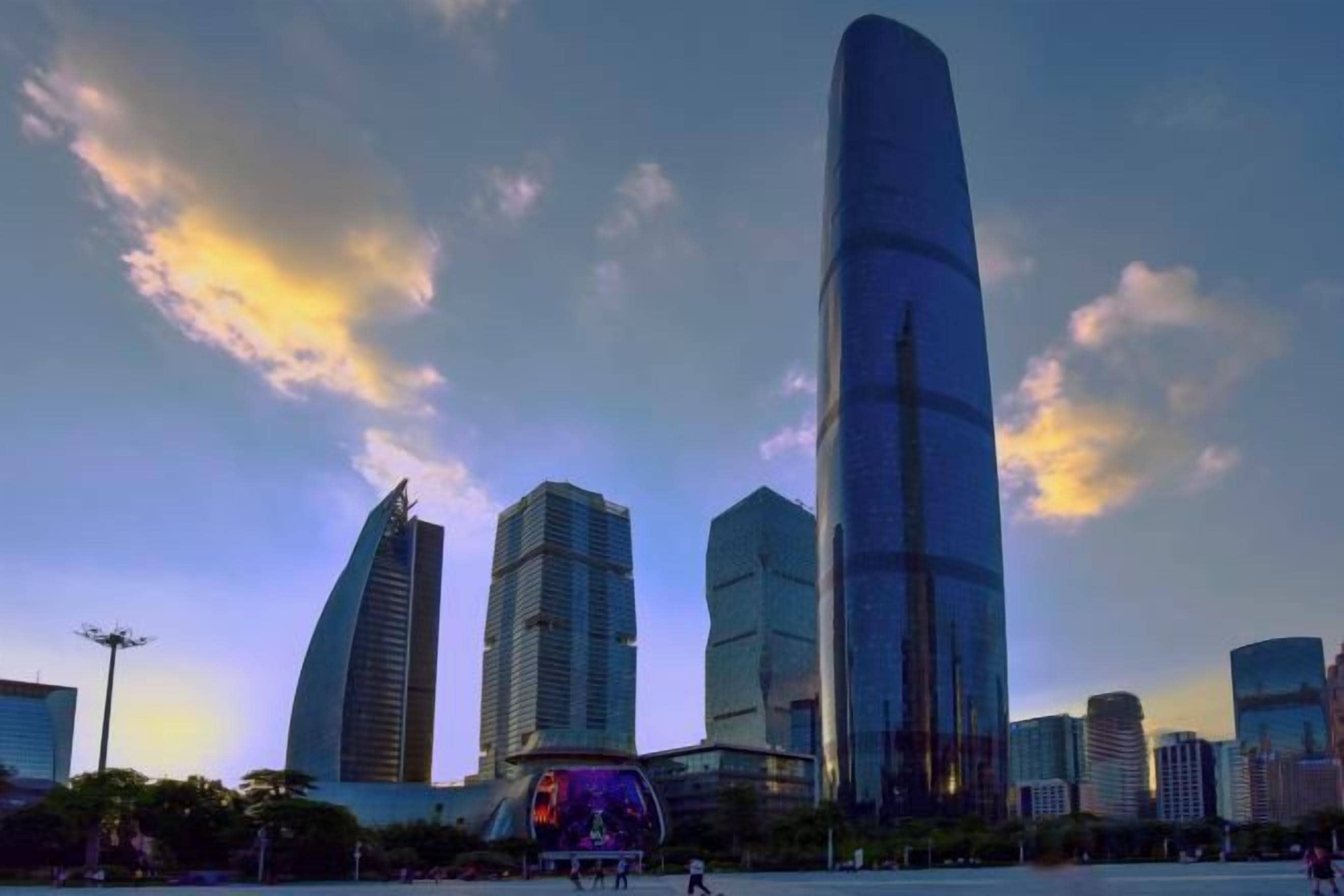 A cityscape with modern skyscrapers, including a prominent curved building and a tall, slender skyscraper.