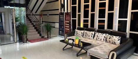 A modern living area with a sofa set, a coffee table, and a staircase.
