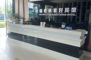 A hotel reception desk with a sign indicating 'REJUN TO THE GUEST GOOD HOTEL'. - Ruijun Laikehao Hotel Jingzhou (Jingzhou)