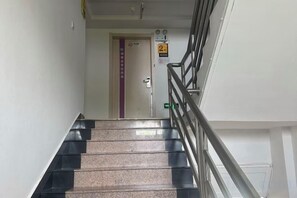 Una scala con corrimano che conduce a una porta con la scritta 'secondo piano'.