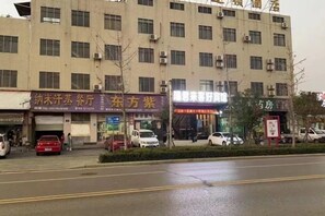 A multi-story building with commercial establishments on the ground floor, including a restaurant and a pharmacy. - Ruijun Laikehao Hotel Jingzhou (Jingzhou)