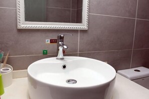 A bathroom with a white sink, a mirror, and a toilet. - Ruijun Laikehao Hotel Jingzhou (Jingzhou)