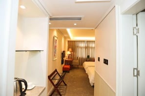 Une chambre d’hôtel avec un lit, une table de chevet, une lampe et une chaise.