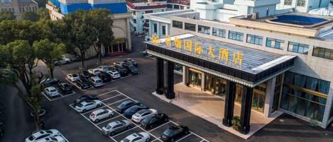 Un edificio a più piani con un parcheggio antistante.