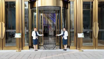 A hotel entrance with revolving doors and a signboard.