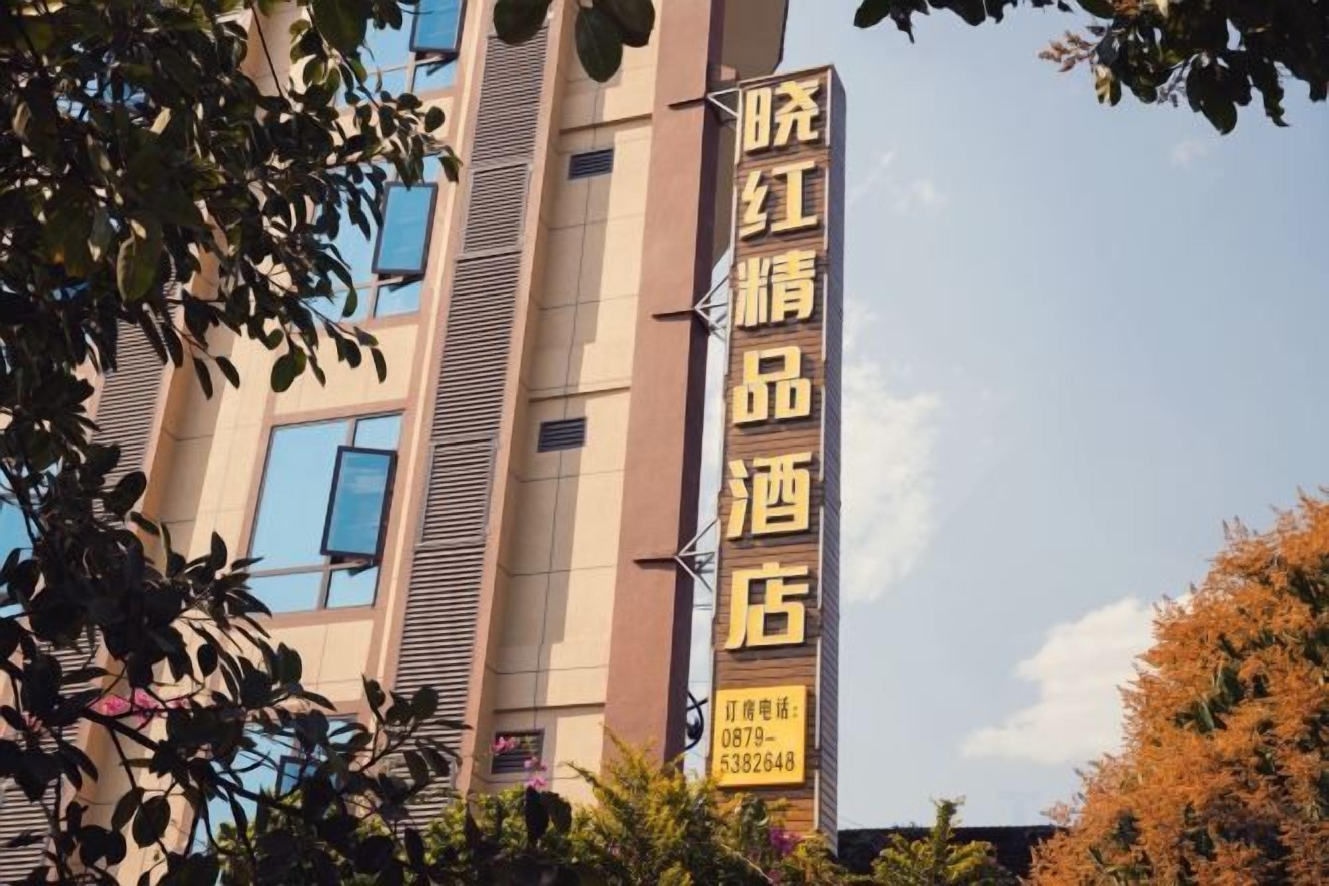 A hotel sign with a vertical layout, featuring a prominent name and contact information.