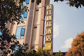 Une enseigne d’hôtel de forme verticale, avec un nom bien visible et les coordonnées de l’établissement.