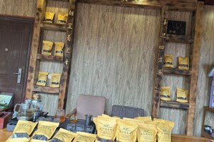 Un interior de madera con estantes llenos de bolsas de té y una mesa con una tetera y tazas.