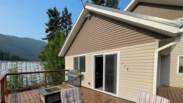 A deck with a grill, chairs, and a table. - Cozy Getaway in Mullan (Mullan)
