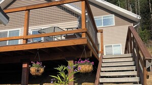 A two-story wooden house with a balcony and a staircase leading to the upper level. - Cozy Getaway in Mullan (Mullan)