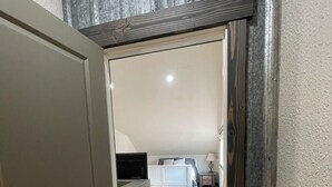 A bedroom with a bed, bedside table, lamp, and a view of a living area. - Cozy Getaway in Mullan (Mullan)