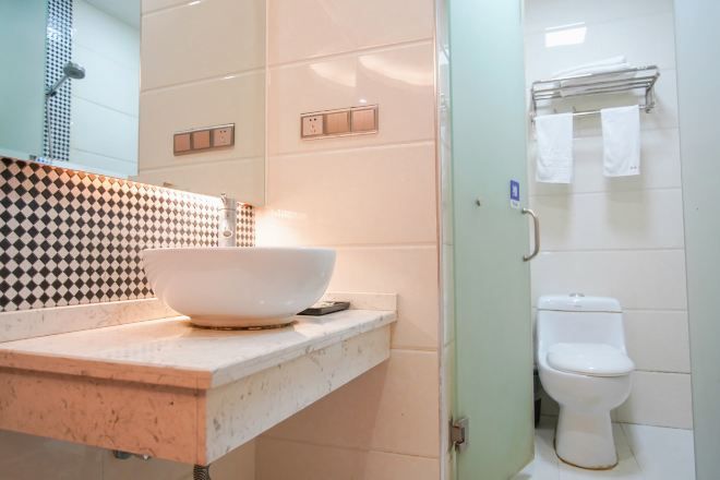 Ein Badezimmer mit Waschbecken, Spiegel und Toilette.
