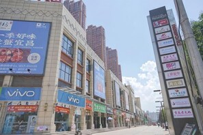 A street with commercial buildings, including a Vivo store.