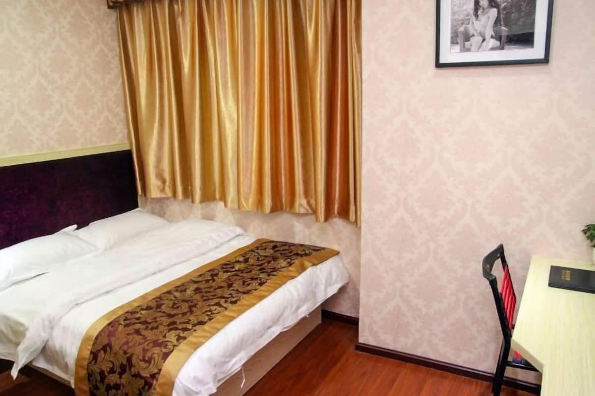 Una habitación de hotel con una cama, un escritorio y una silla.