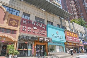 A hotel with multiple signs, including one for a business hotel and another for a restaurant.
