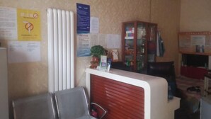 A reception area with a counter, chairs, and various informational posters on the walls. - Harbin Summer Hotel (Harbin)