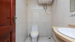 A small bathroom with a toilet, a sink, and a shower unit. - Harbin Summer Hotel (Harbin)