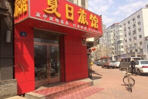 A red building with a sign that reads 'Xia Jiang Travel Hotel.' - Harbin Summer Hotel (Harbin)