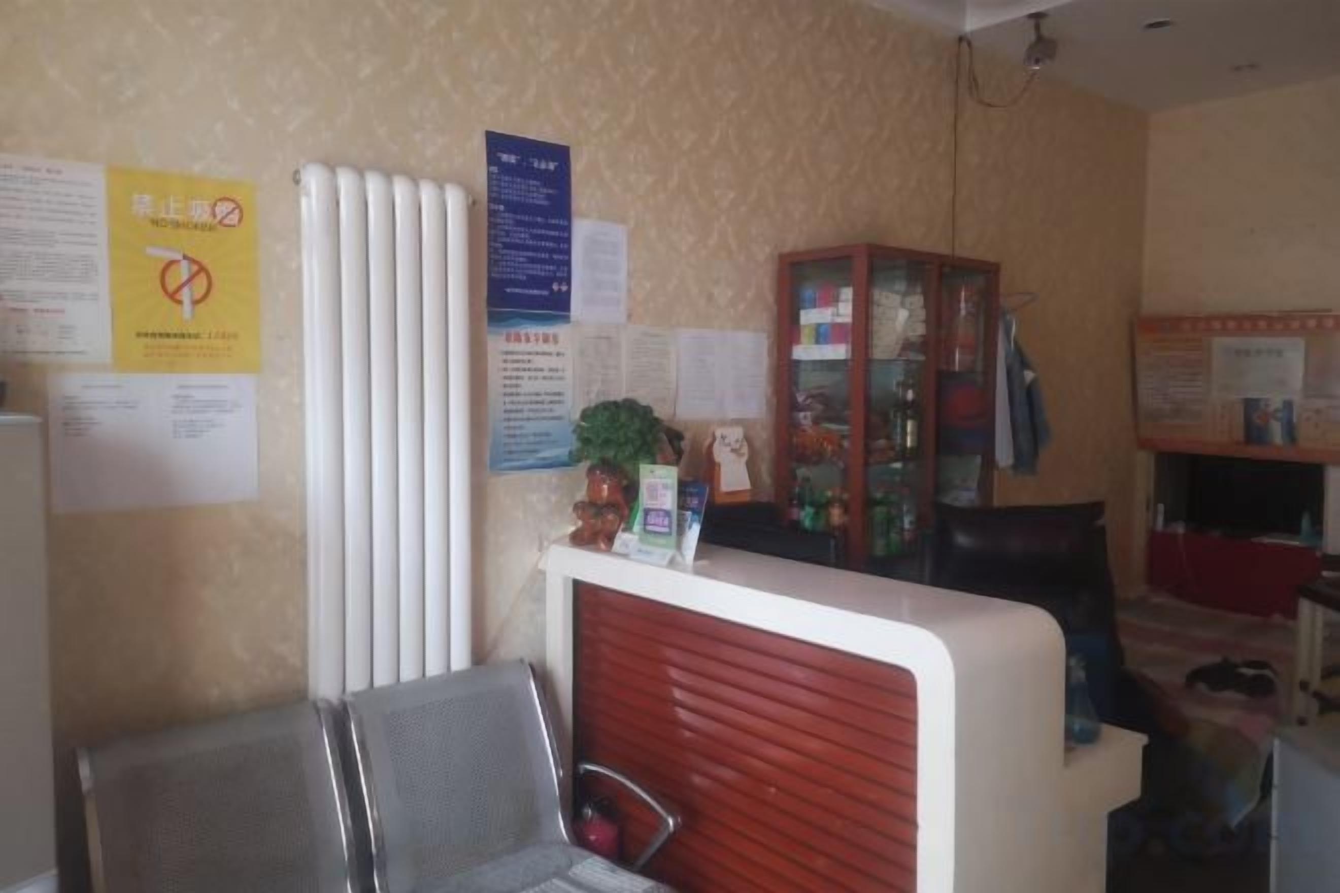 Un área de recepción con mostrador, sillas y carteles informativos en la pared.