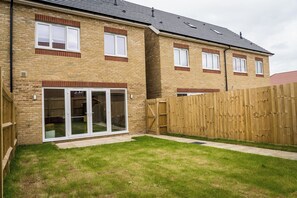 A two-story brick house with a fenced backyard and a sliding glass door leading to a patio. - 3 Bedroom, 3.5 Bathroom House, Goodwood, Chichester (Chichester)